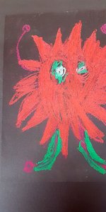 Auf einem Blatt ist ein rotes Monster gemalt.
