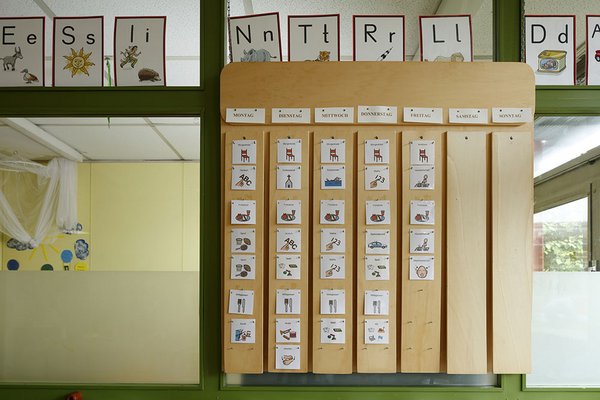 Eine Holztafel mit Karten zeigt den Stundenplan für die ganze Woche.