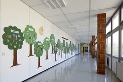 Im Flur sind Bäume an der Wand. Blätter und Früchte stehen für die Menschen, die in der Laurentius-Schule lernen und arbeiten.
